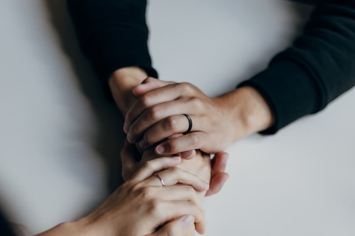 Two people holding hands, a gesture of comfort and reassurance.